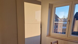 A kitchen with a refrigerator, a window, and a table with chairs. - Fantastic Apartment in the Heart of Wedel (Wedel)