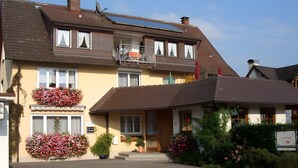 Un bâtiment à deux étages doté d’un balcon, de jardinières et d’une enseigne indiquant qu’il s’agit d’un restaurant.