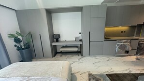 Une chambre d’hôtel moderne équipée d’un lit, d’un bureau et d’une kitchenette.