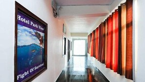 Un pasillo con un cartel de un pájaro y un pez, y una fila de cortinas a la derecha.