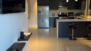A modern kitchen with a central island, stainless steel appliances, and pendant lighting.