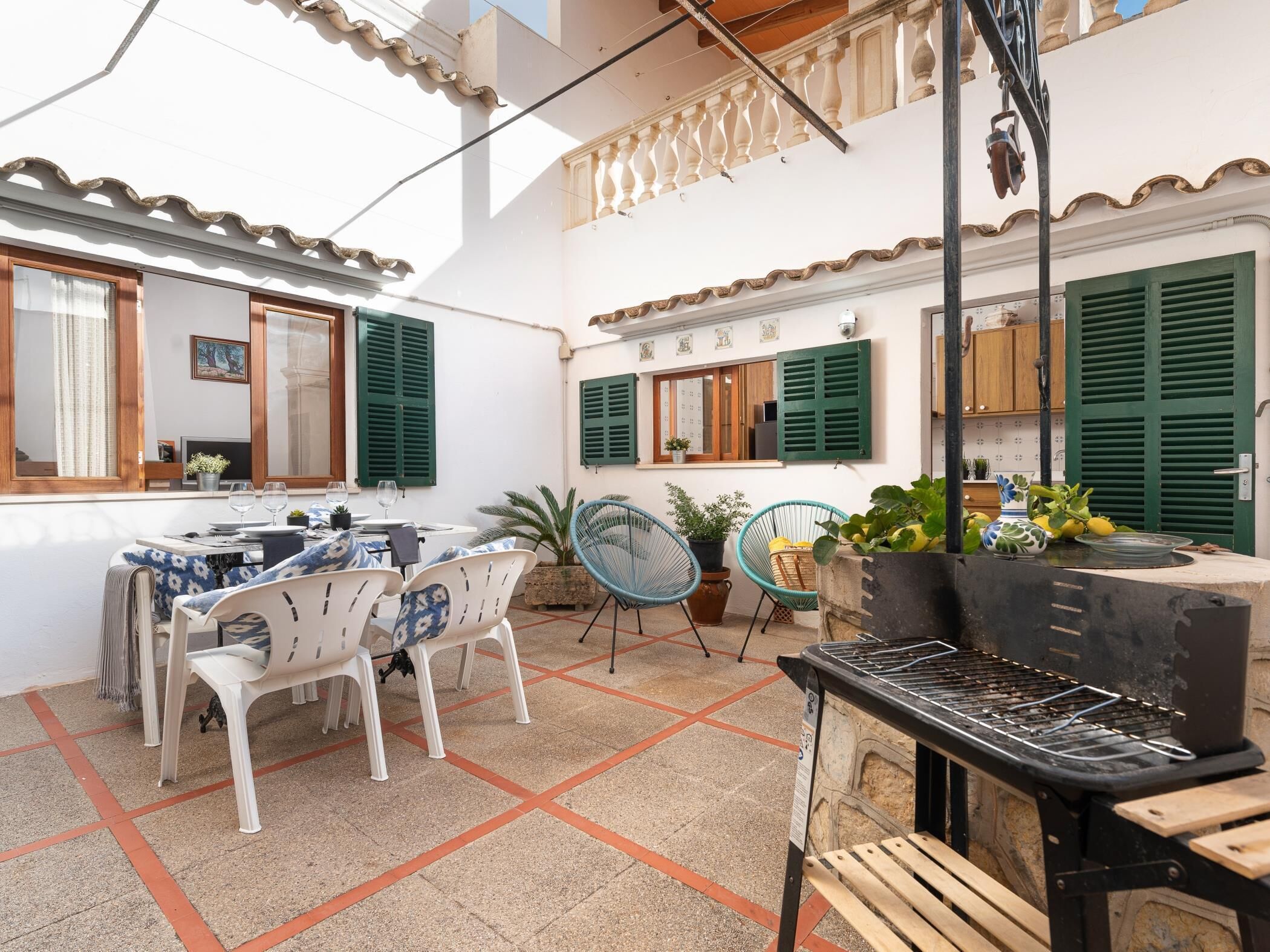 A patio with a dining table, chairs, and a grill.