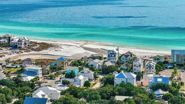 Un pueblo costero con propiedades frente al mar y una playa de arena.