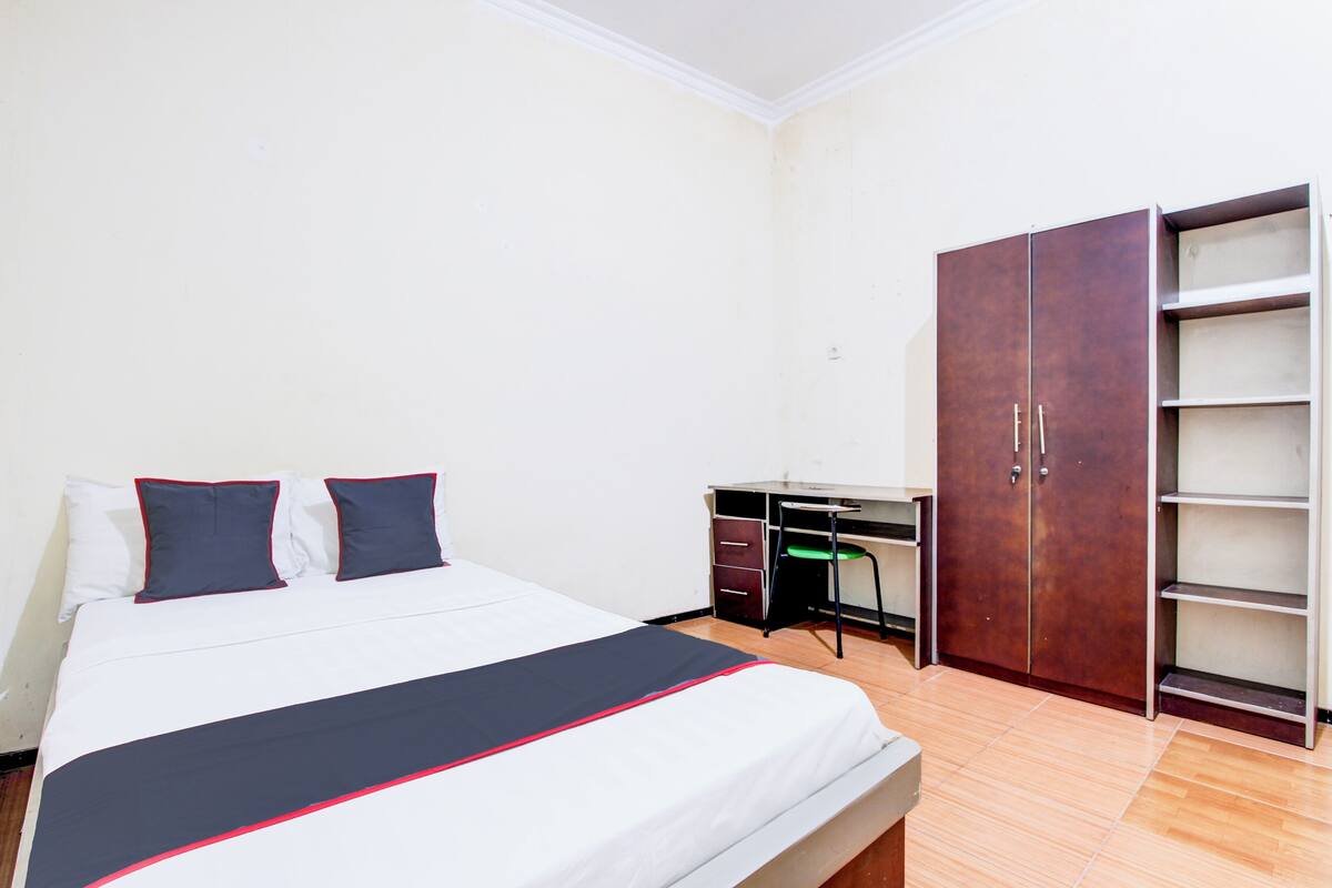 Une chambre à coucher avec un lit, un bureau et une armoire.