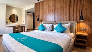 A hotel room with a bed, a desk, and a mirror. - Kana Suites Nusa Dua By Fays Hospitality (Nusa Dua)