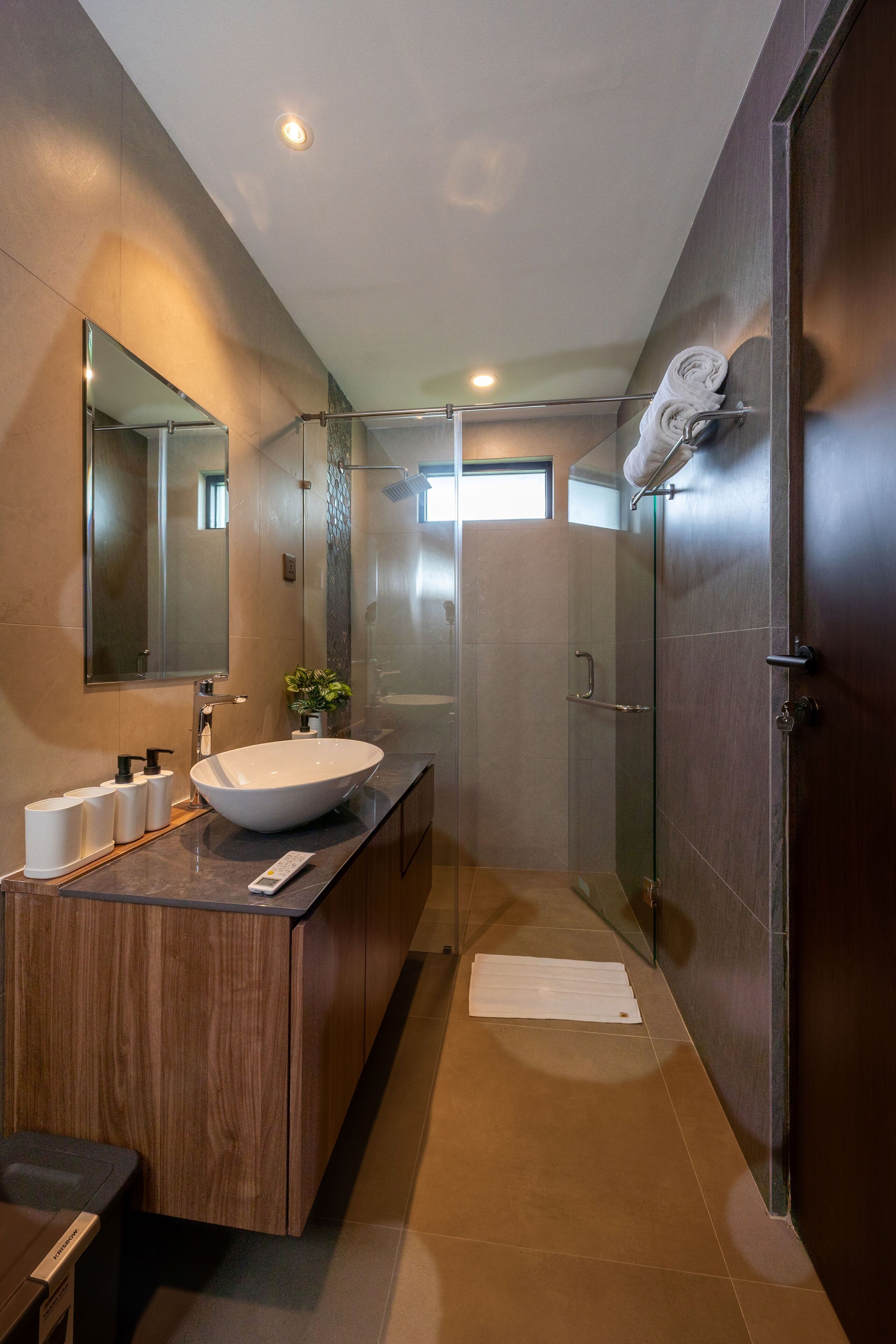A modern bathroom with a large sink, mirror, and shower.