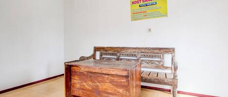 A room with a wooden bed and a desk. There is a sign on the wall.