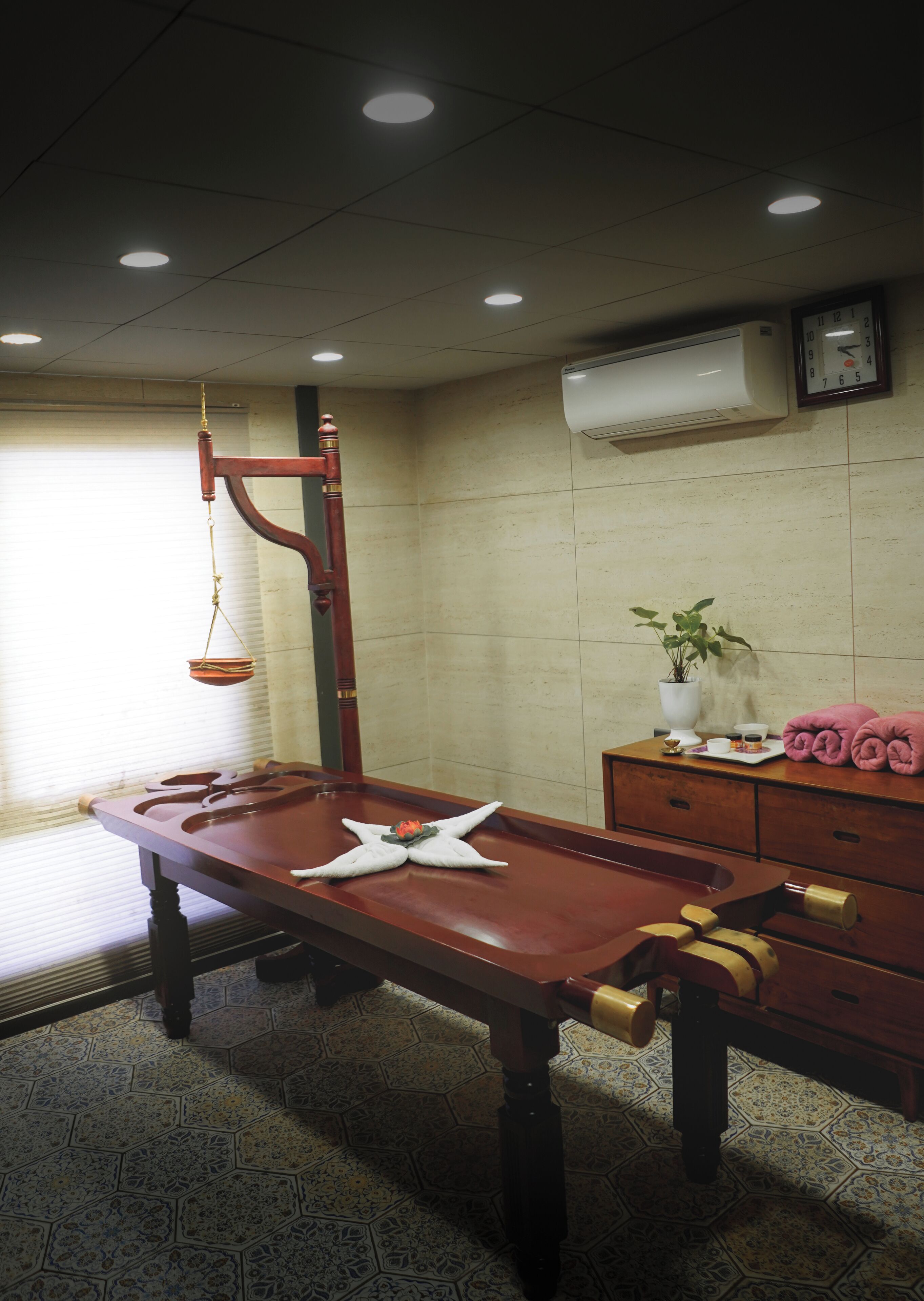Una habitación con una mesa de billar de madera, una balanza colgante, un reloj y una planta en maceta.