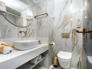 A modern bathroom with a white sink, gold fixtures, and marble walls. - Rhodos Horizon Boutique – Adults Only (Rhodes)
