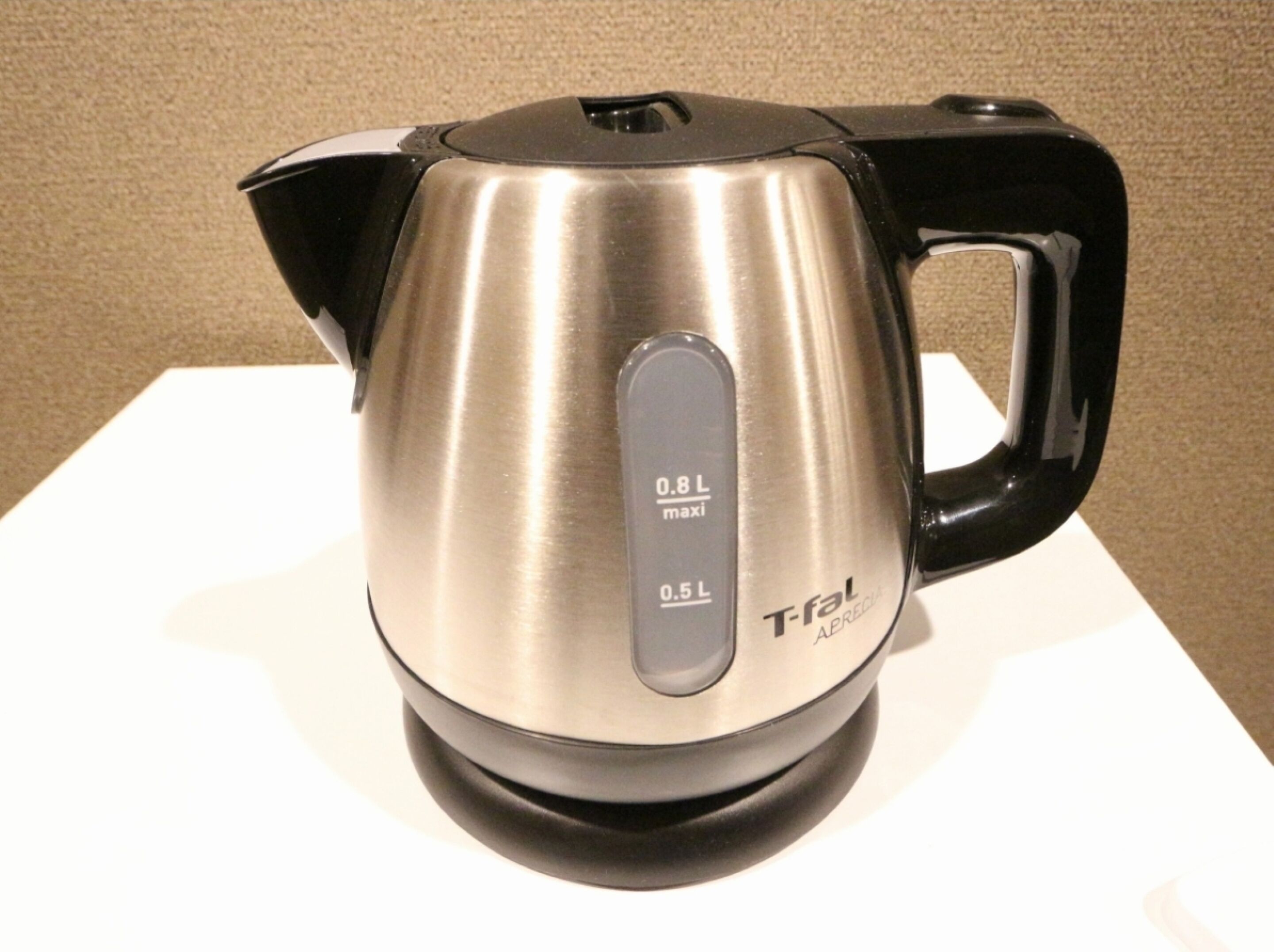 A stainless steel electric kettle with a black handle and base, featuring a digital display indicating 0.8 L max and 0.5 L current.