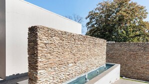 Un muro de piedra con una piscina integrada.