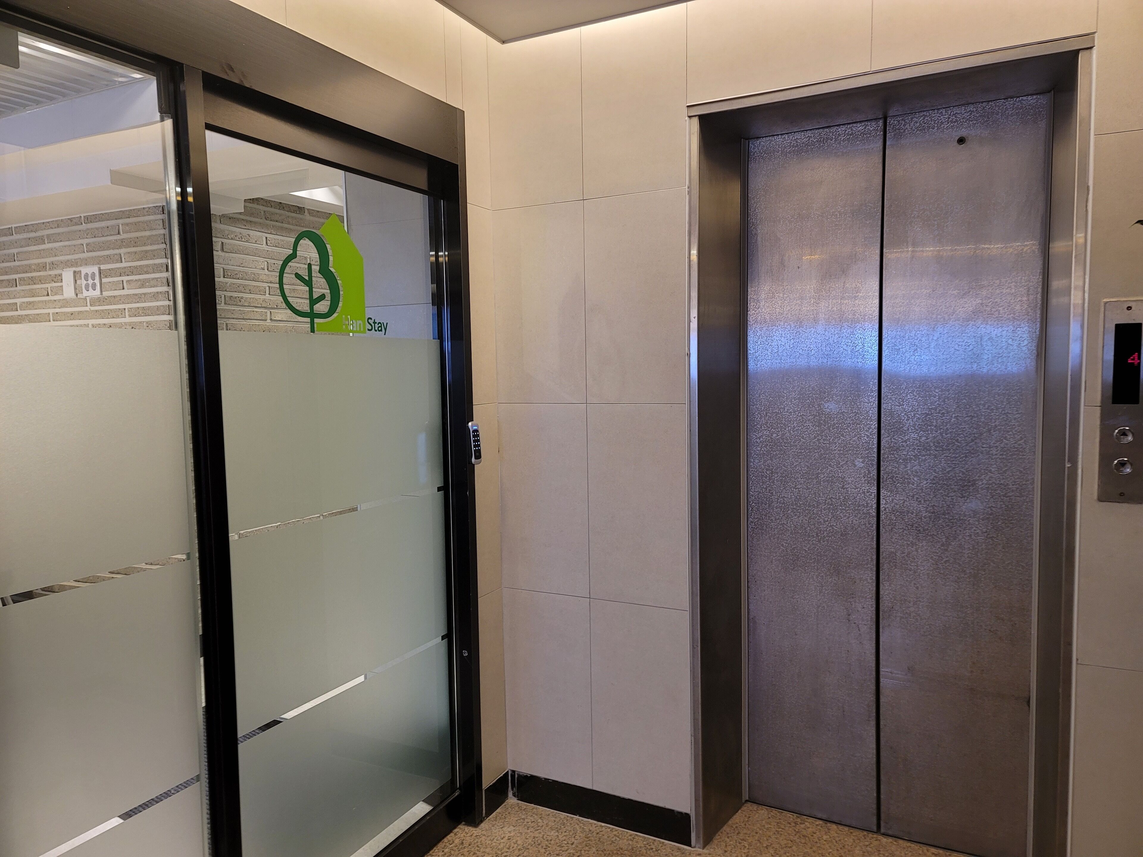 An elevator with a metallic finish and a digital display showing the number 4.