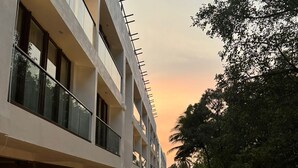 Un edificio de varios pisos con una galería techada y vistas a árboles.