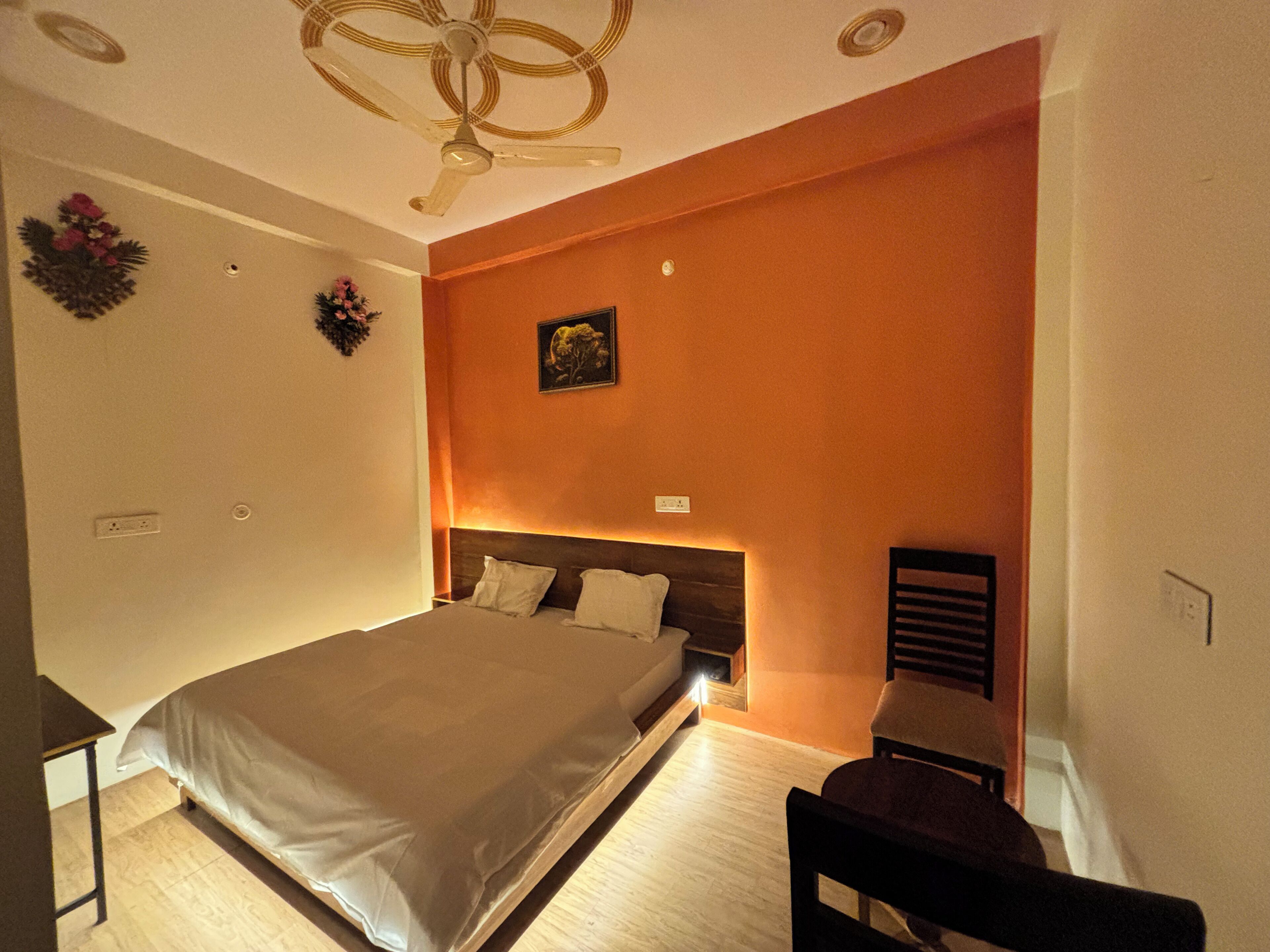 A bedroom with a large bed, a desk, and a chair.