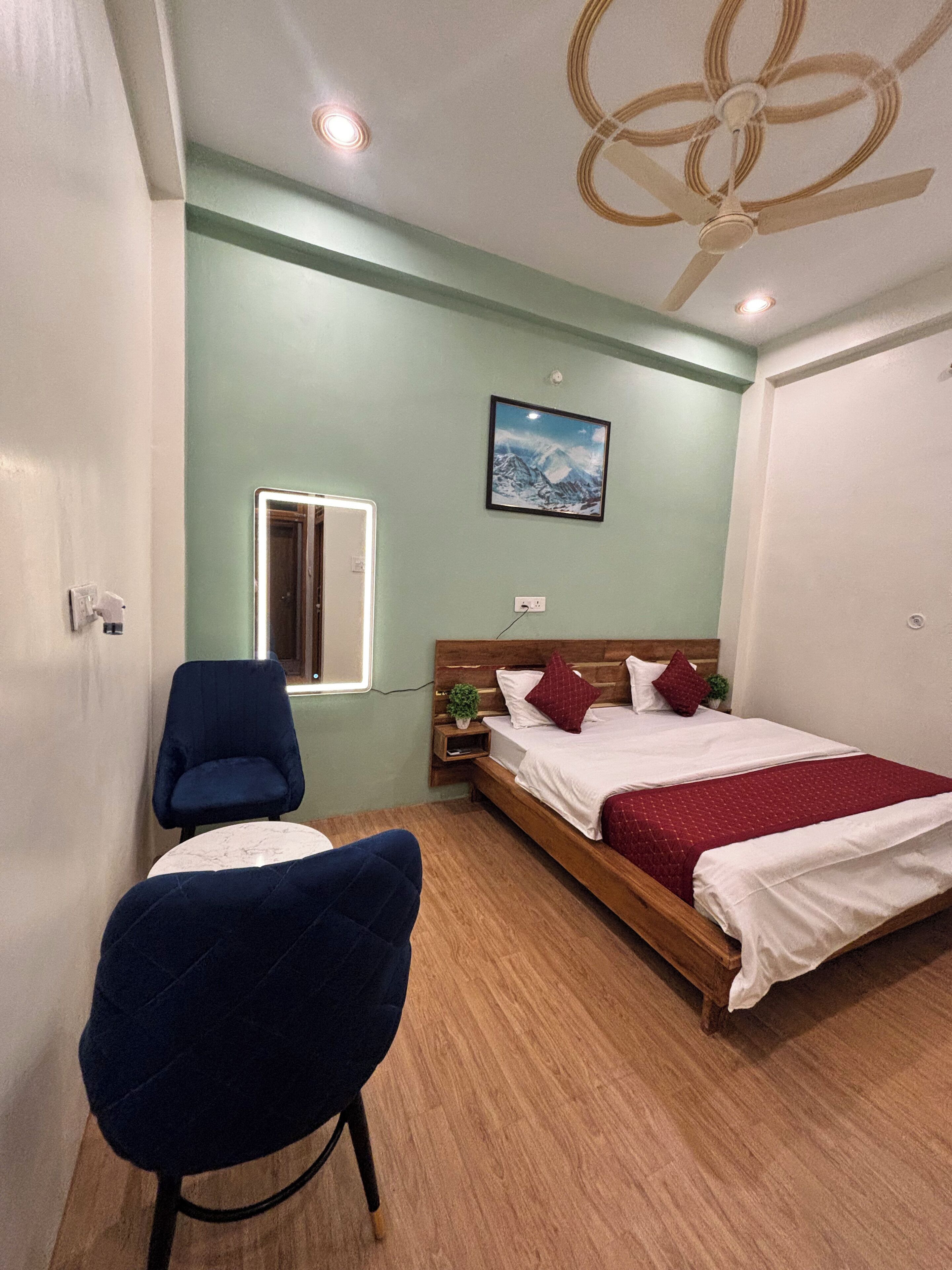 A bedroom with a bed, a chair, a window, and a ceiling fan.
