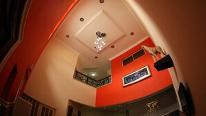 Un interior de varios niveles con una decoración en rojo y blanco, un candelabro y una estatua de jirafa.