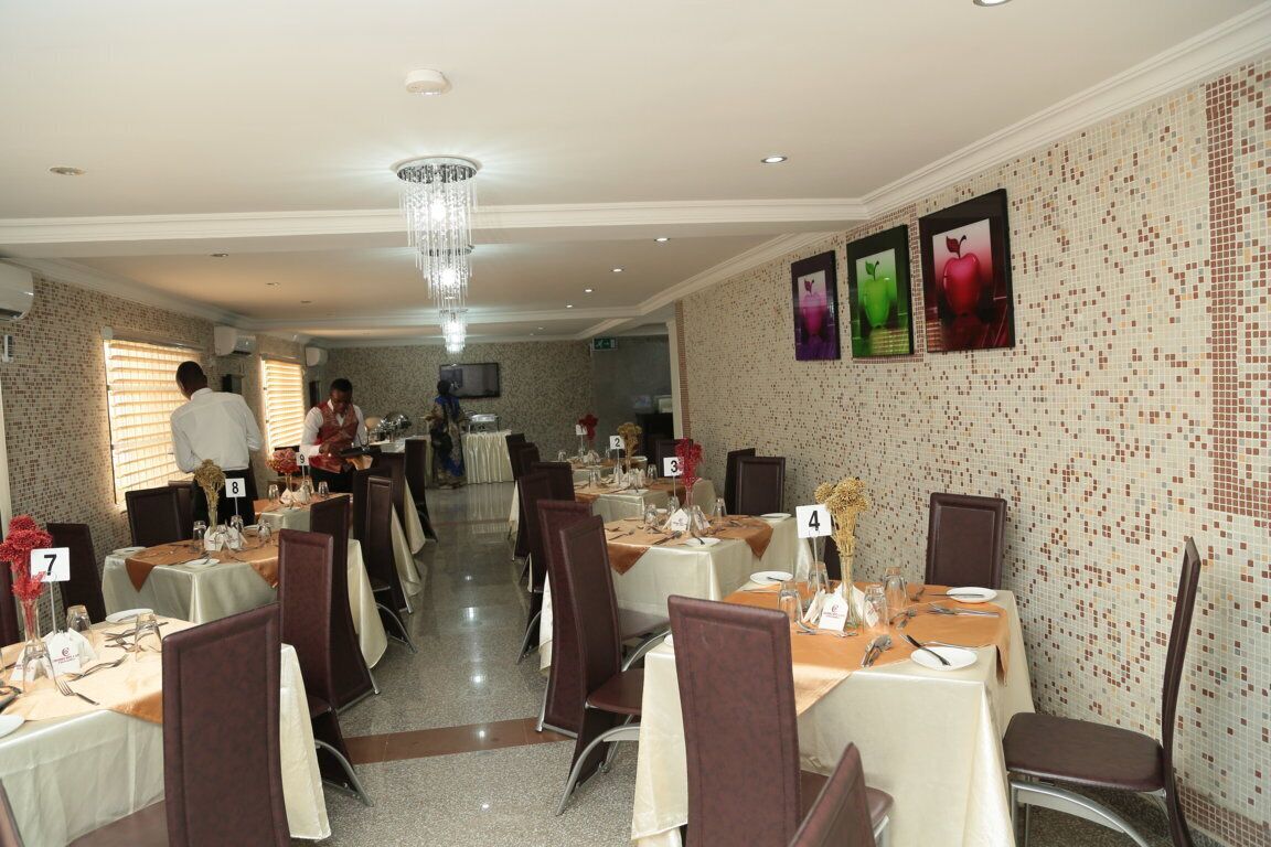 A dining area with tables set for service, numbered seating, and a chandelier.
