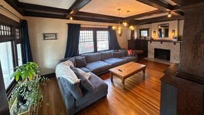 Un salon moderne avec un canapé d’angle, une table basse en bois et une cheminée.
