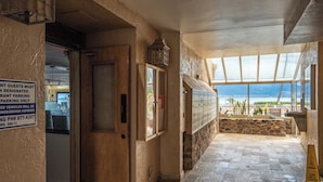 Ein Restaurant mit Blick auf den Strand, ein Schild für ausgewiesene Parkplätze und ein Warnschild bezüglich des Fußbodens.