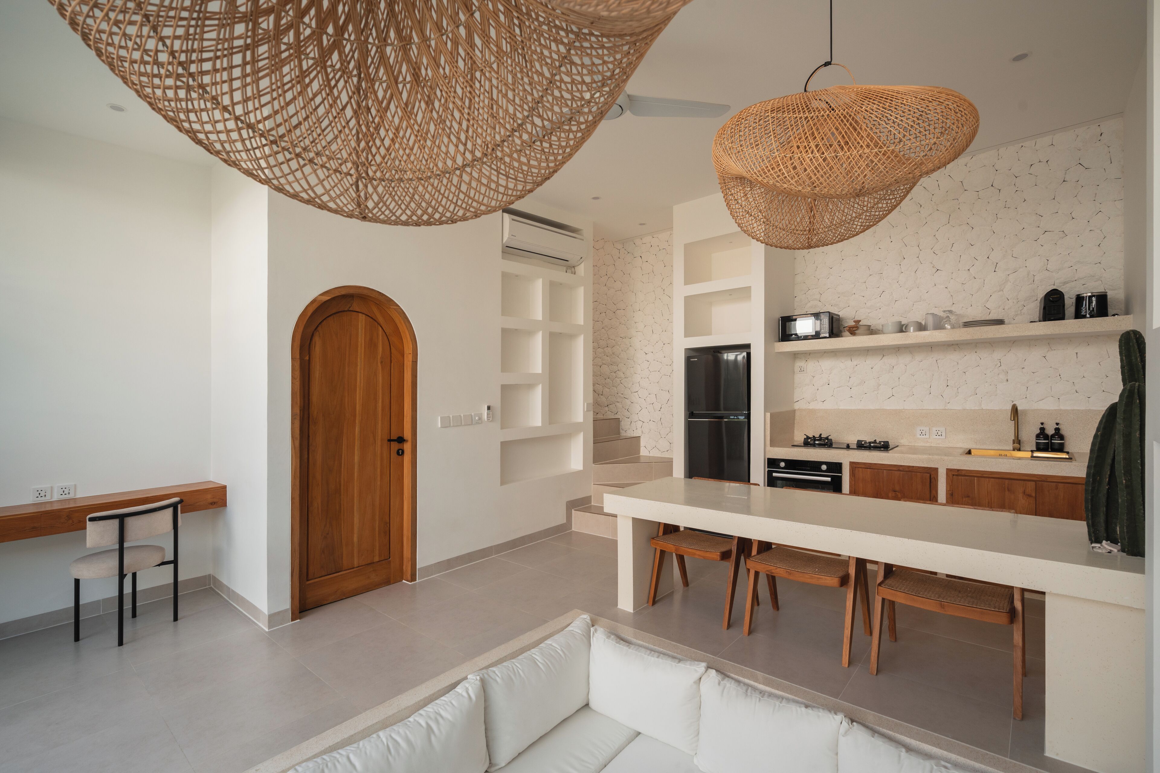 A modern kitchen with a central island, wooden cabinets, and a built-in oven.