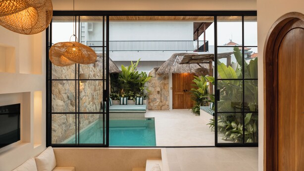 A modern interior with a pool, stone walls, and tropical plants. - Villa Kaia by Alfred in Bali (Canggu)
