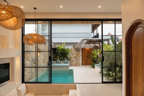 Un interior moderno con piscina, paredes de piedra y plantas tropicales.