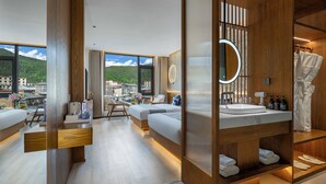 A modern bathroom with a large mirror, wooden accents, a built-in sink, and a view of the city.