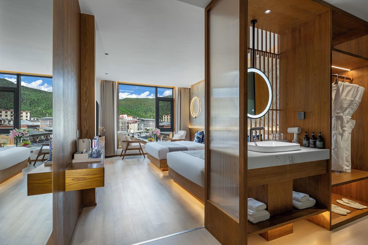 Un baño moderno con un espejo grande, detalles de madera, un lavamanos integrado y vistas a la ciudad.