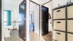 Een hotelkamer met een bed, een kledingkast en een badkamer die door een geopende deur zichtbaar is.
