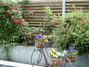 Bicycles are parked in a serene garden setting surrounded by lush greenery and vibrant flowers.