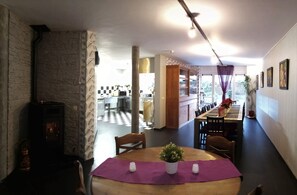 Enjoy meals in this stylish dining area with a long table, comfortable chairs, and a cozy fireplace.
