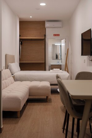 Cozy retreat with a single bed, seating area, and wardrobe.