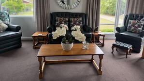 Ein Wohnzimmer mit Kamin, zwei Sofas, einem Couchtisch und einem großen Spiegel an der Wand.