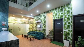 A modern lobby with a sofa, coffee table, and a staircase leading to an upper level. - Hotel Sky View (New Delhi)