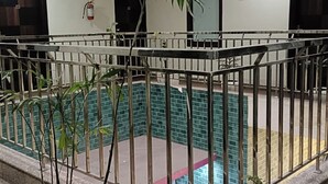 A swimming pool with a tiled border and a metal railing. - Hotel Sky View (New Delhi)