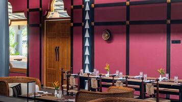 Um restaurante com esquema de cores vermelho e preto, móveis de madeira e vista para o exterior.