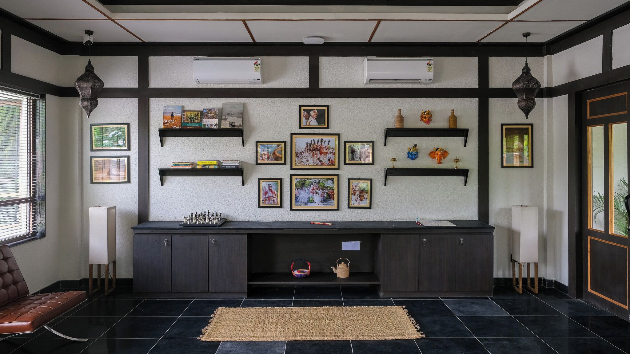 Un salon moderne avec une cheminée, des étagères à livres et des tableaux encadrés accrochés au mur.