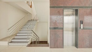 Interior moderno com escada, elevador e parede com textura.