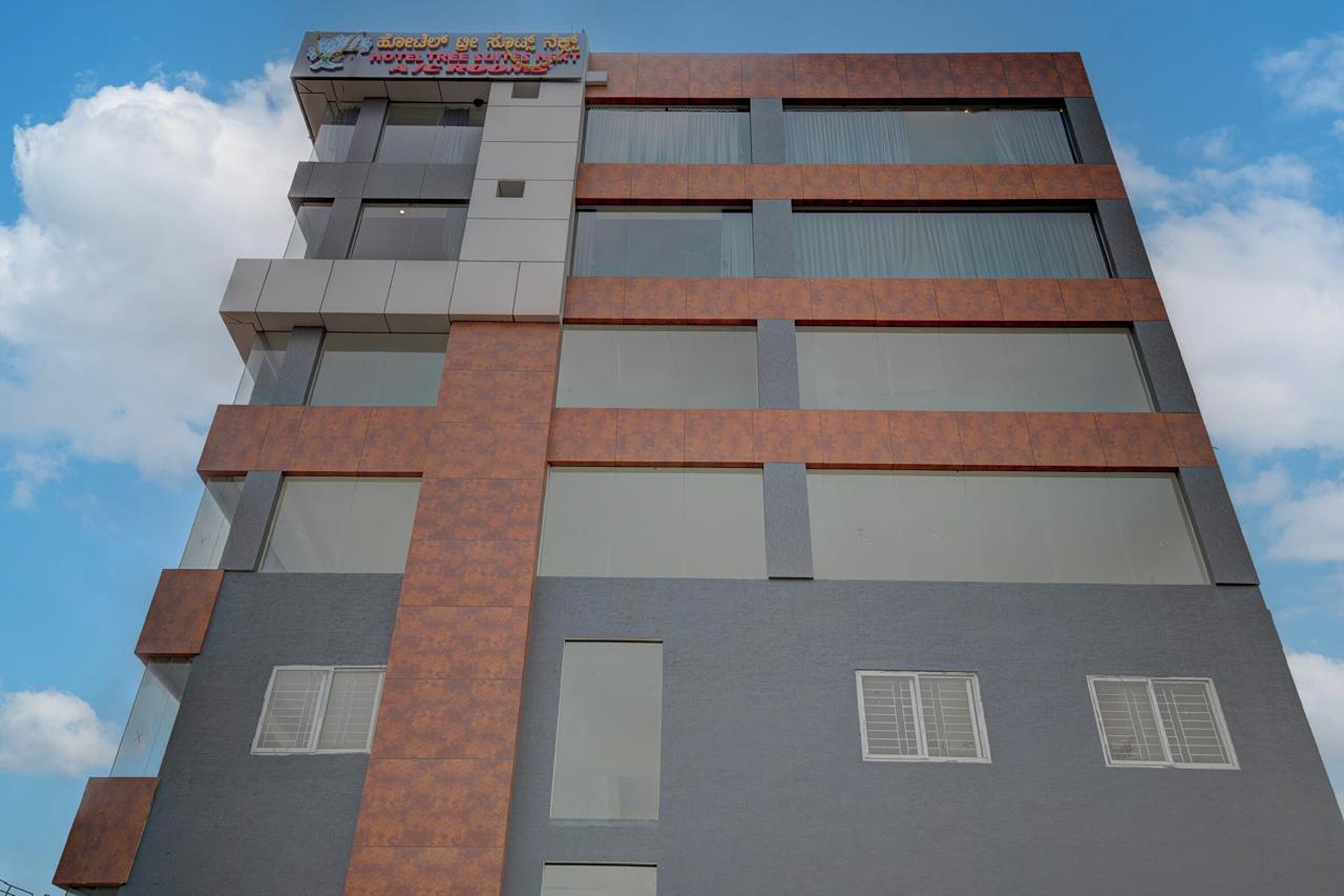 Un edificio de varios pisos con un diseño arquitectónico moderno, que combina elementos de vidrio y metal.