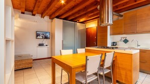 Un interior de madera con cocina, una mesa de comedor con sillas y una pequeña zona de estar.