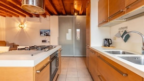 Una cocina moderna con armarios de madera, un lavamanos de acero inoxidable y un horno empotrado.
