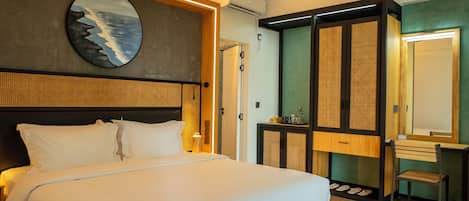 Una habitación de hotel moderna con una cama grande, cabecera de madera, una obra de arte colgada en la pared, un armario con espejo y un escritorio con silla.