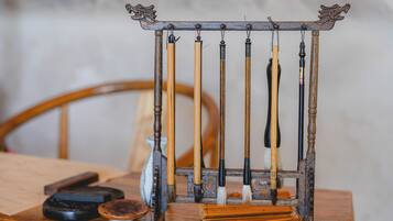 Ein hölzerner Ständer mit verschiedenen traditionellen Pinseln und einem kleinen Tintenkleckers.