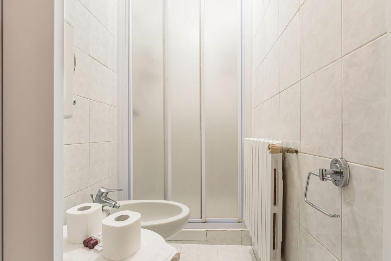 Een badkamer met toilet, wastafel en douche.