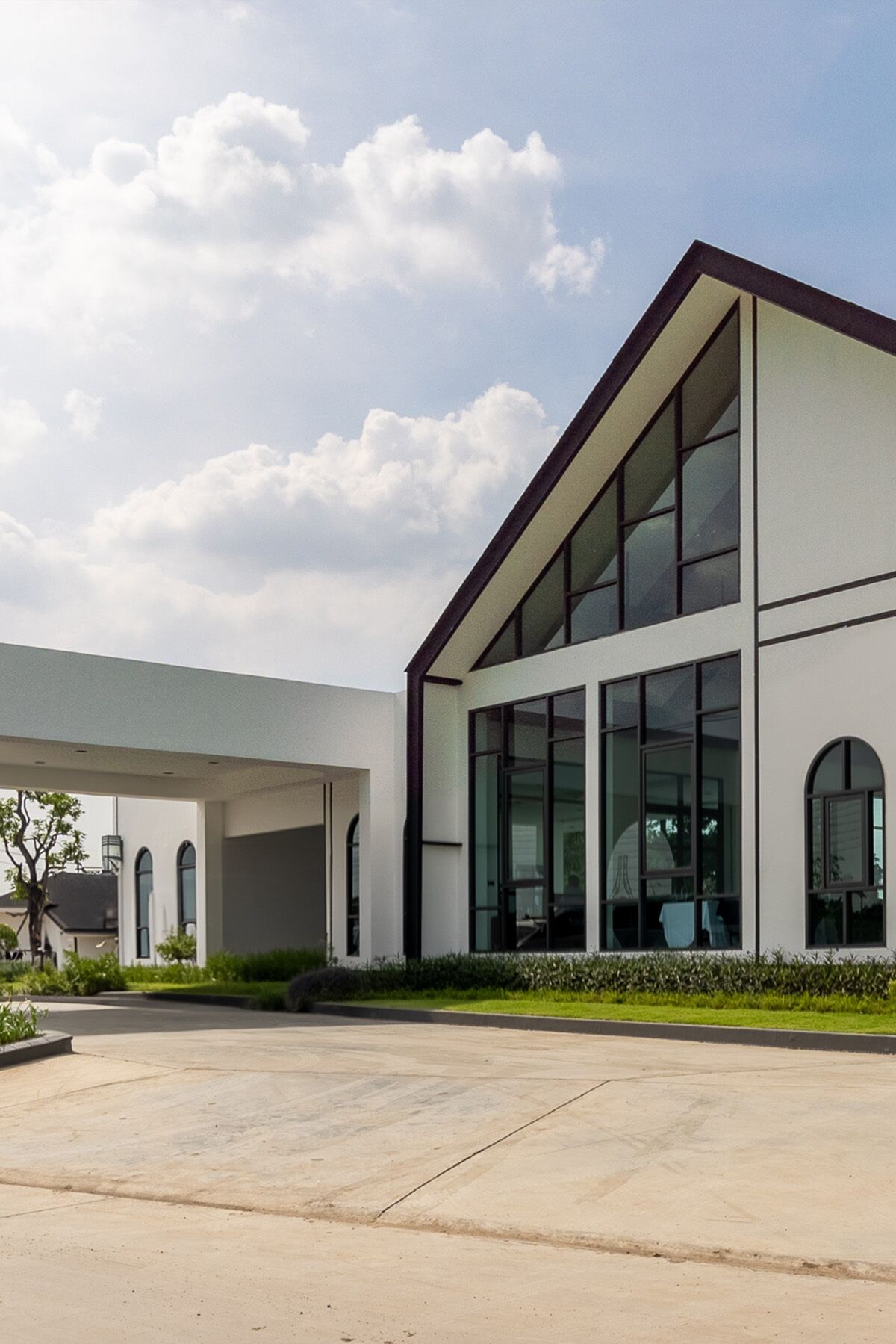 A modern building with a flat roof, large windows, and a covered entrance area.