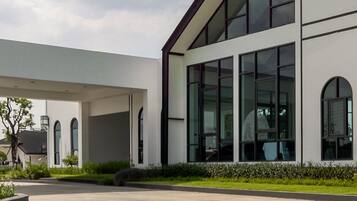 A modern building with a flat roof, large windows, and a covered entrance area.