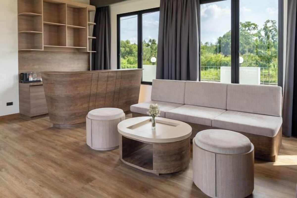 A modern living room with a sofa, two round tables, and a wooden coffee table.