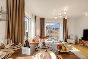 A dining area with a table set for four, a bottle of wine, and a 'Welcome' sign.