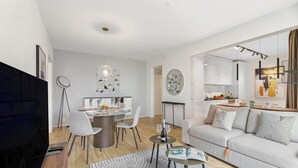 A modern living room with a sofa, coffee table, and dining area. - Novos Contrada Apartments (Lugano)