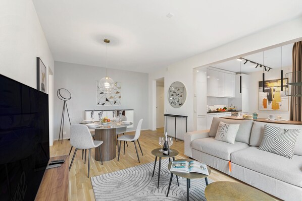 Een moderne woonkamer met een bank, salontafel en een eethoek.